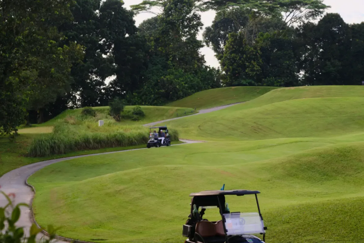 Golf cart on a winding cart path across a golf course